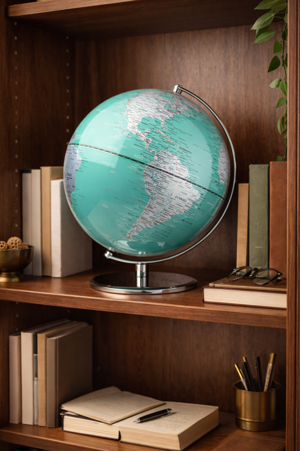 Turquoise globe on wooden bookshelf