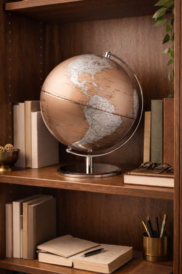 Globe and books on a wooden shelf